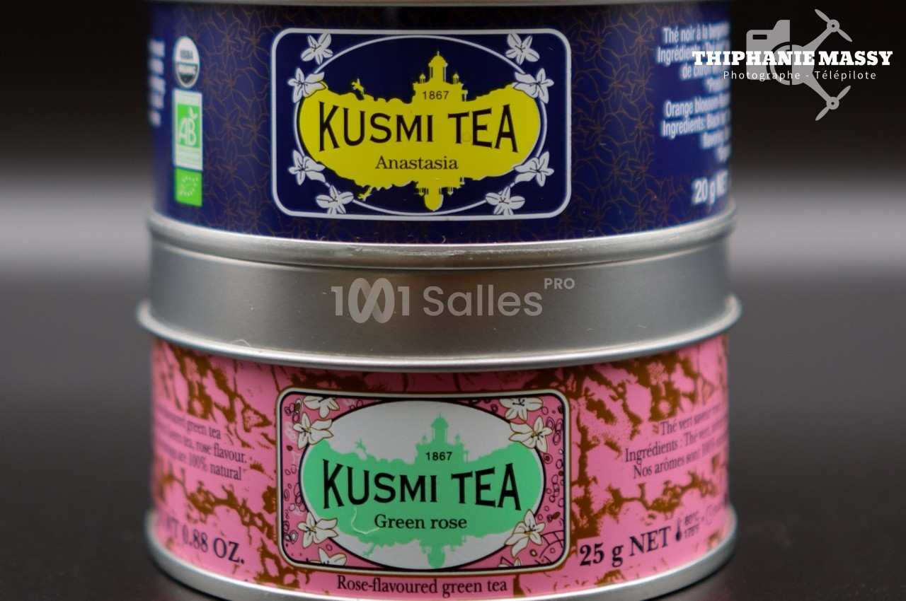 Deux boîtes de thé Kusmi Tea empilées, l'une bleue ’Anastasia’ et l'autre rose ’Green Rose’.