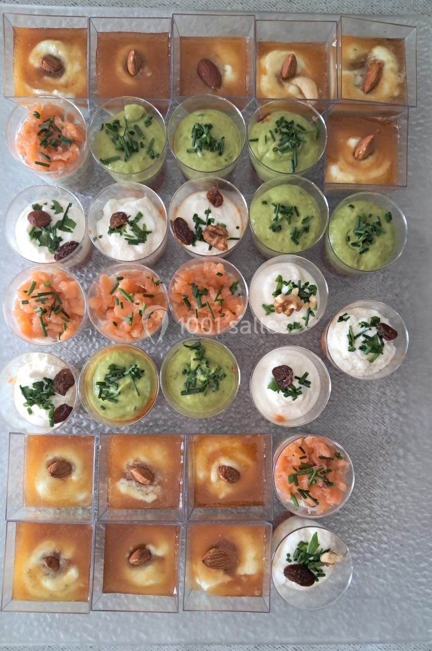 Plateau de verrines variées avec des préparations salées et sucrées, garnies d'herbes, d'amandes et de saumon.