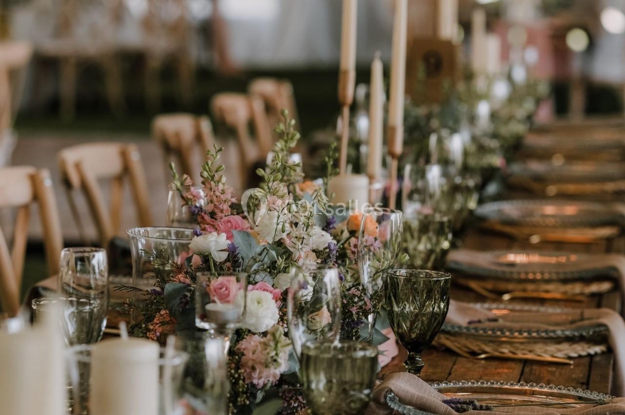 Table décorée avec des fleurs, bougies et vaisselle élégante dans un cadre de réception.