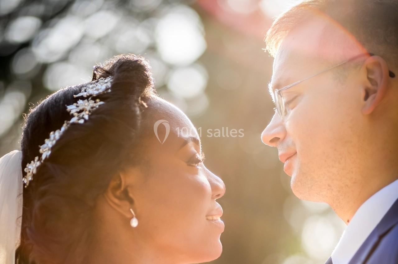 Un couple se regarde avec tendresse sous une lumière naturelle douce, en extérieur.
