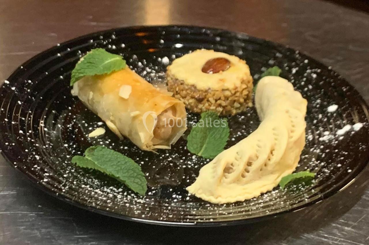 Assiette de desserts comprenant une pâtisserie roulée, une crème glacée et un gâteau décoré de menthe.