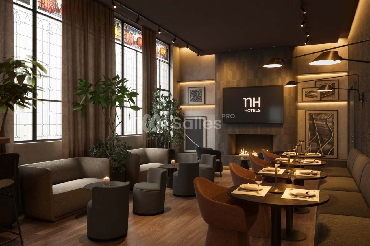Salle de restaurant élégante avec tables dressées, fauteuils confortables, cheminée et vitraux en arrière-plan.