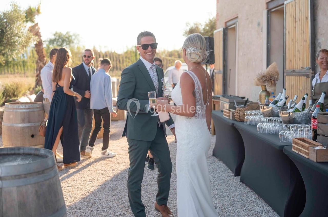 Un couple élégant discute en souriant lors d'une réception en plein air près d'une table de buffet.