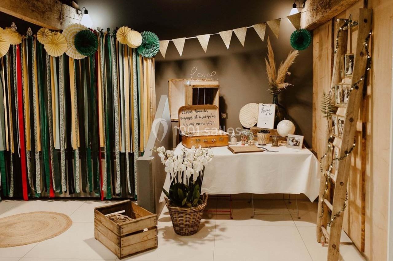 Décoration intérieure avec guirlandes, rubans colorés, table ornée d'objets vintage et plantes dans un cadre chaleureux.