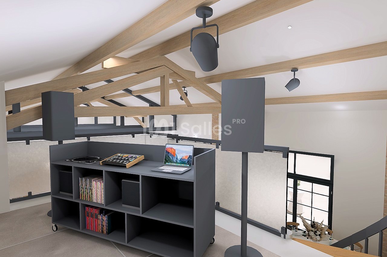 Meuble DJ avec platines, ordinateur portable et enceintes dans un intérieur moderne avec poutres apparentes.