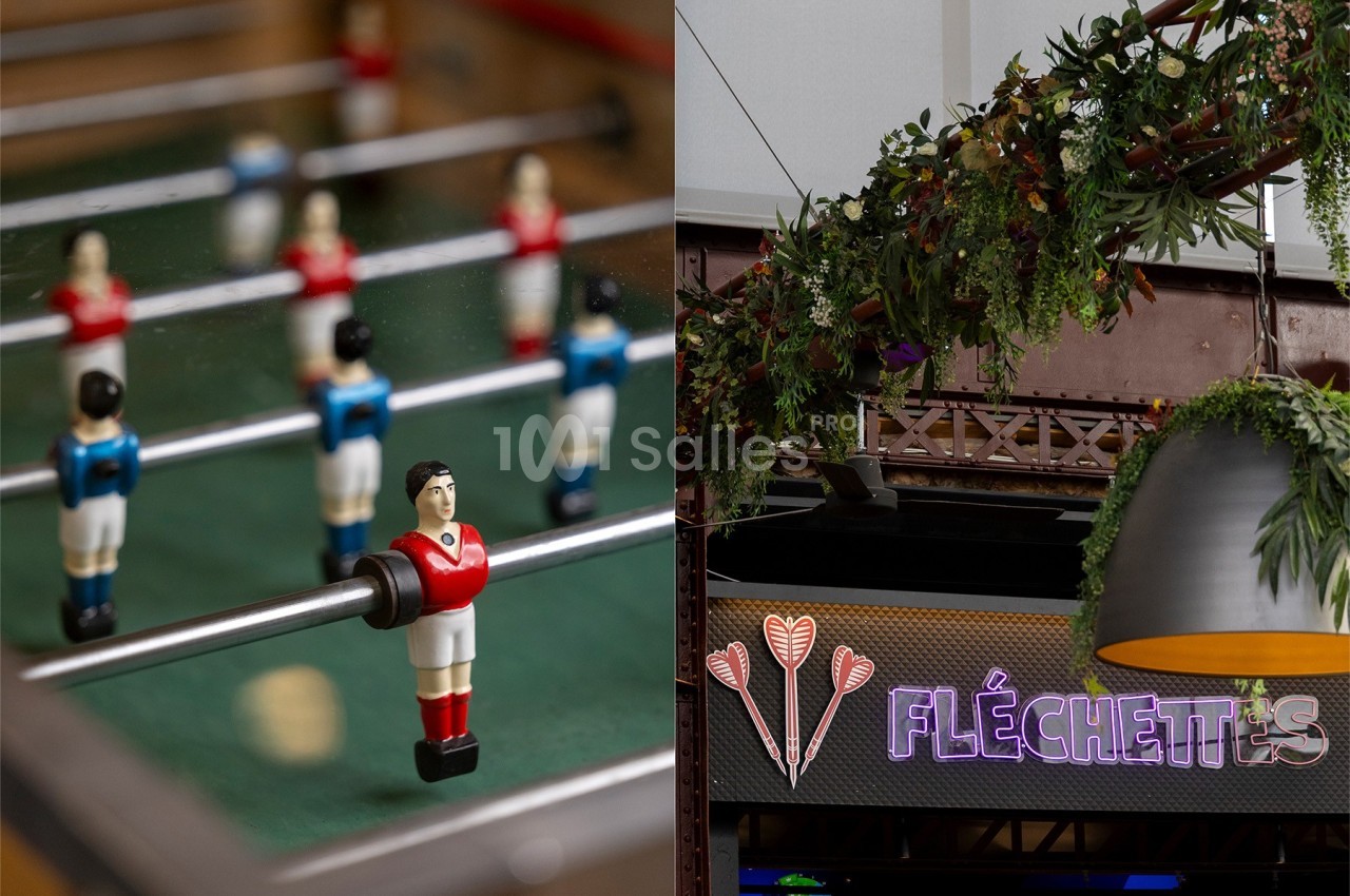 Joueurs miniatures d'un baby-foot à gauche et enseigne lumineuse ’Fléchettes’ avec décor végétal à droite.