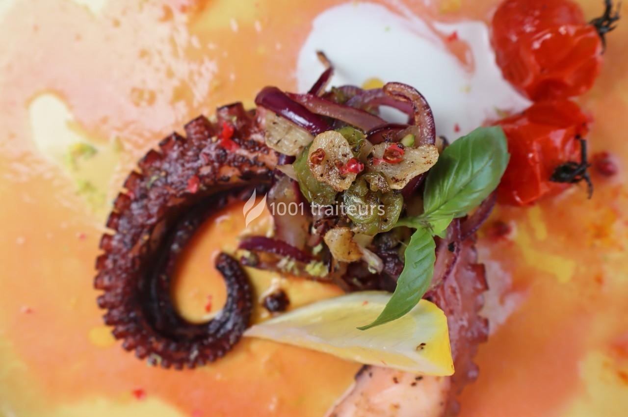 Tentacule de poulpe grillé garni de câpres, ail, basilic, citron et tomates cerises rôties sur une sauce colorée.