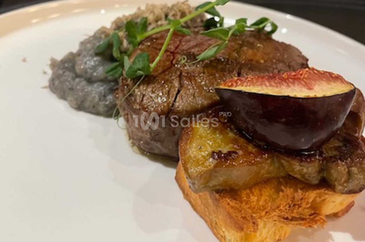 Plat composé d'un filet de viande, d'une tranche de foie gras sur brioche, d'une figue et d'une purée grise, décoré de…
