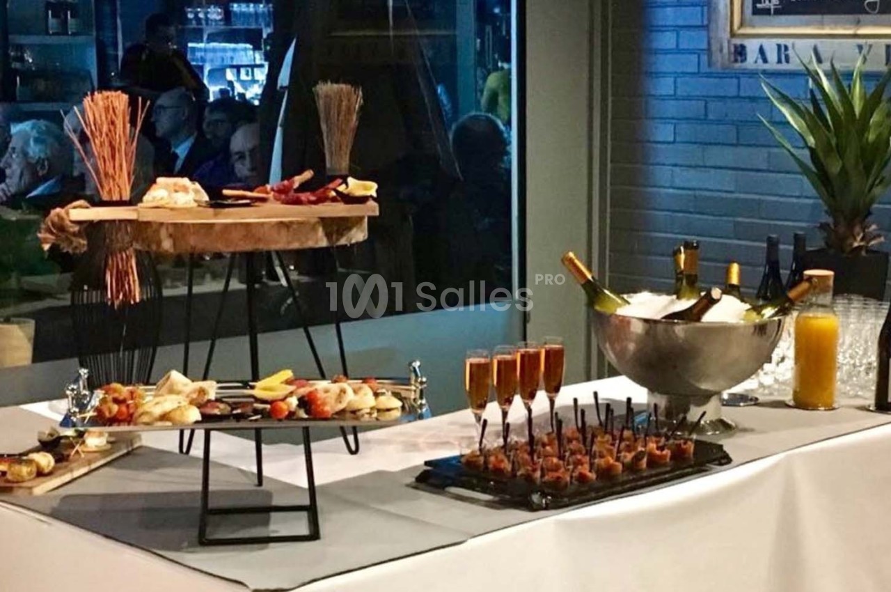 Table de buffet avec amuse-bouches, flûtes de champagne, seau à glace pour bouteilles et décorations rustiques.