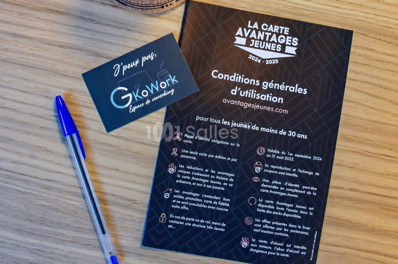 Carte ’Avantages Jeunes’ et flyer explicatif posés sur une table en bois avec un stylo bleu et une carte de visite.