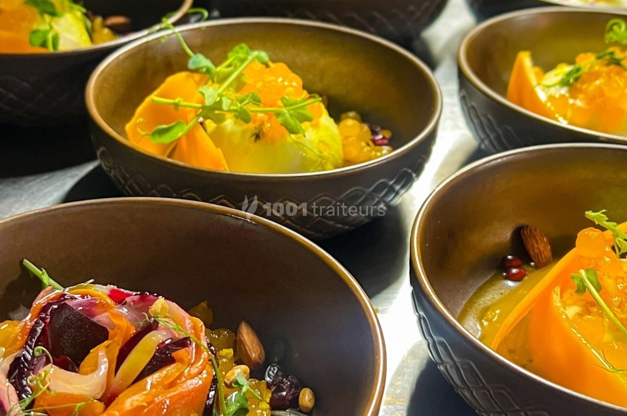 Assiettes de salades colorées avec légumes, fruits, graines et herbes fraîches, servies dans des bols en céramique.