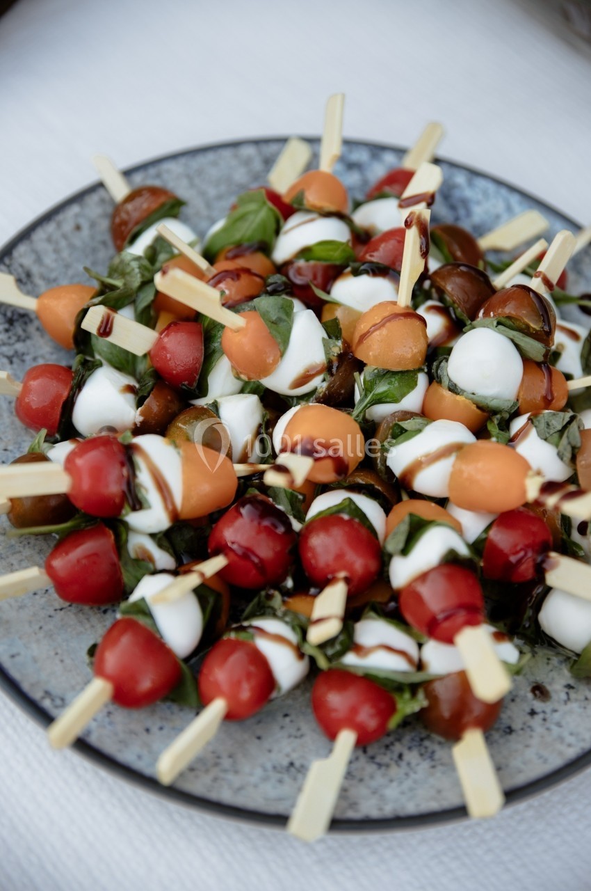 Brochettes apéritives composées de tomates cerises, mozzarella, basilic et filet de vinaigre balsamique.