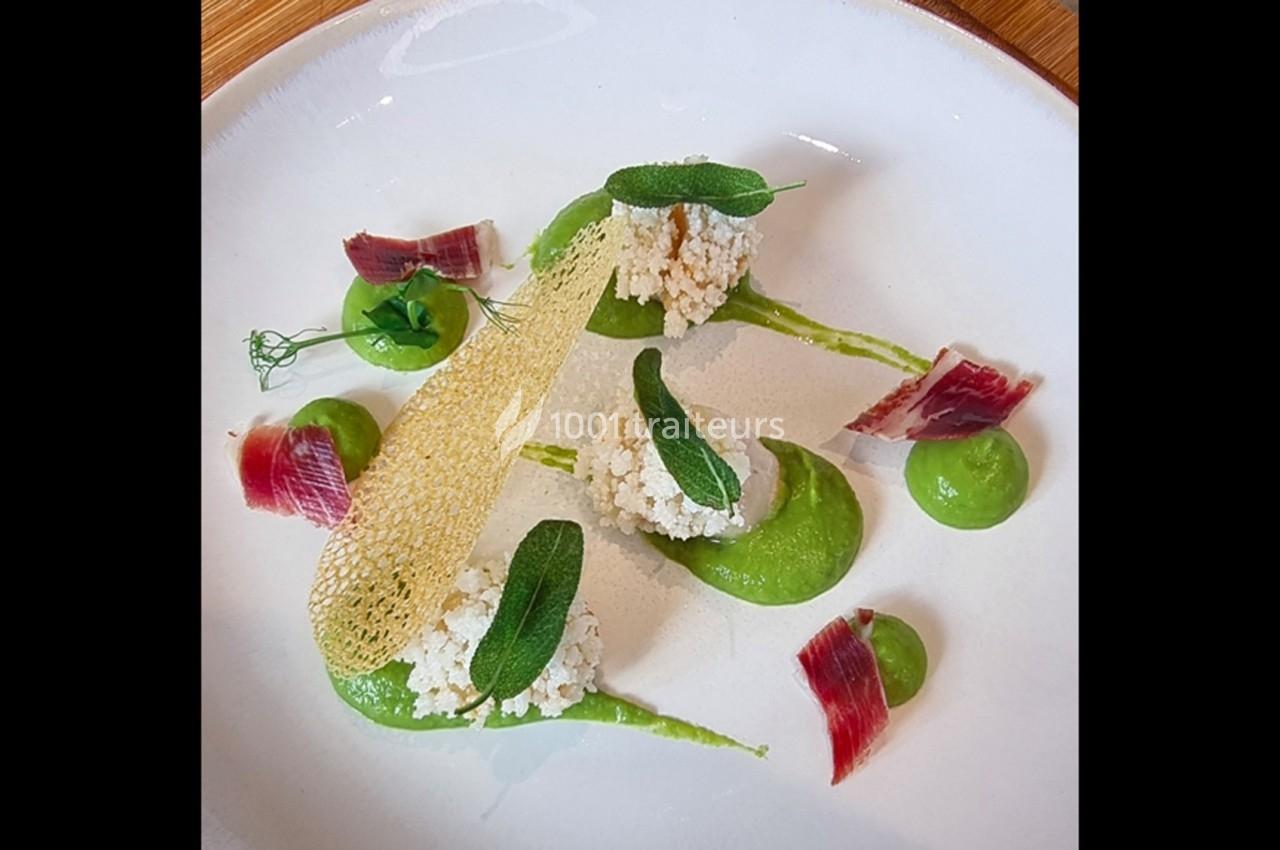 Assiette gastronomique composée de purée verte, croustillant, fromage frais, feuilles de sauge et morceaux de jambon.
