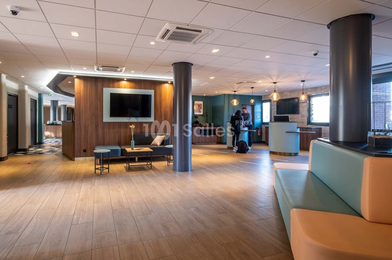 Hall d'entrée moderne avec sol en bois, mobilier épuré, comptoir d'accueil et éclairage chaleureux.