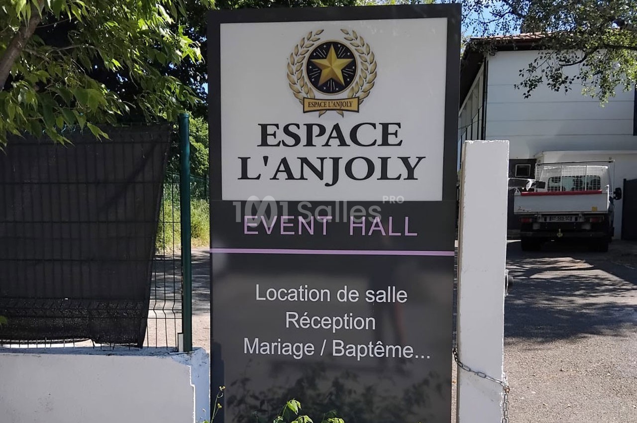 Panneau indiquant ’Espace L'Anjoly Event Hall’ avec des services comme location de salle, mariages et baptêmes.