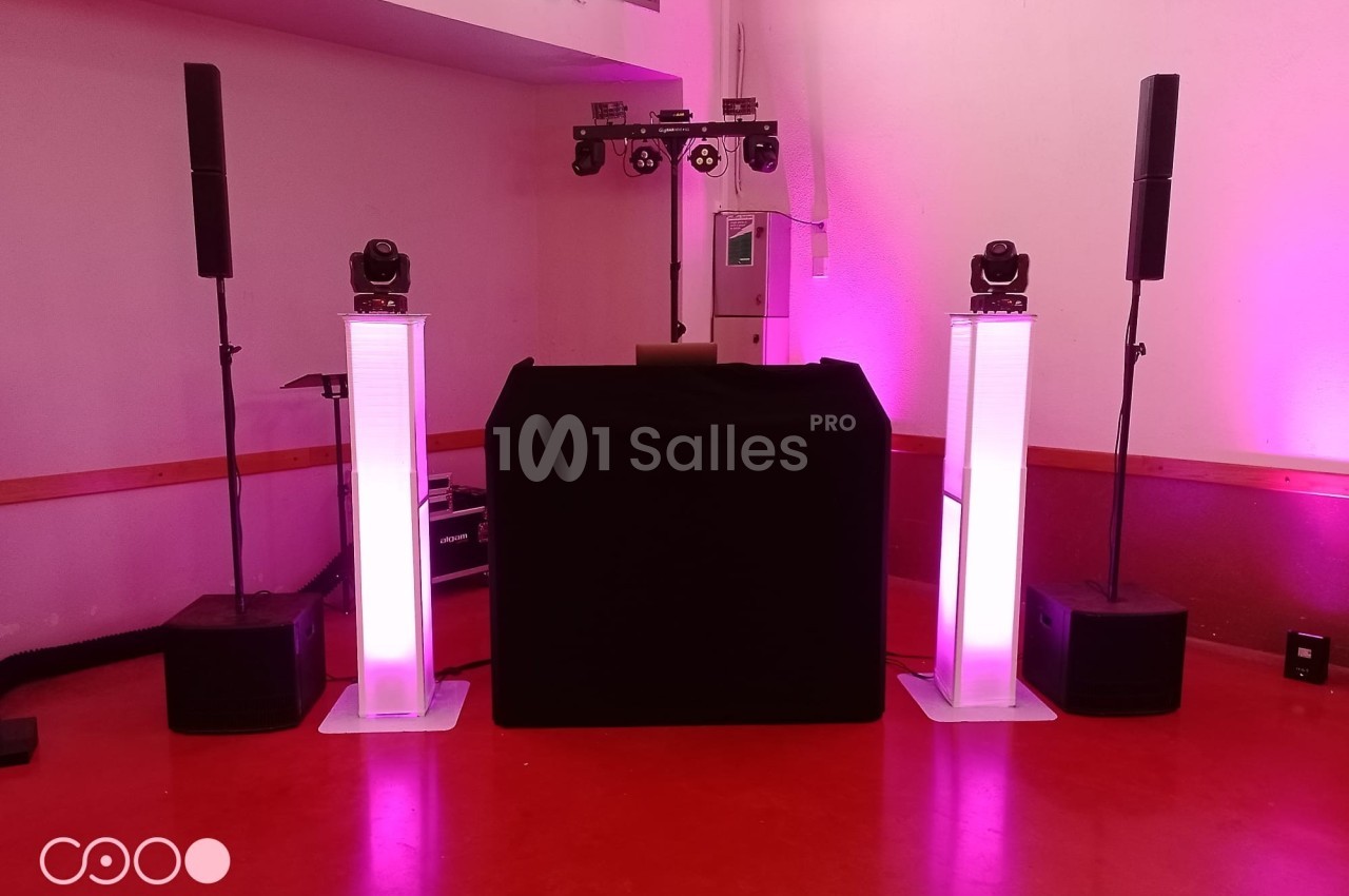 Installation de matériel de sonorisation et d'éclairage avec des colonnes lumineuses dans une salle intérieure.