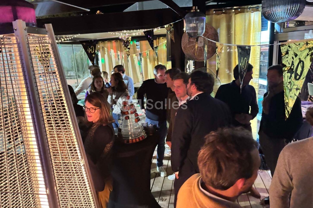 Groupe de personnes discutant dans un espace intérieur décoré avec des lumières et des éléments festifs.