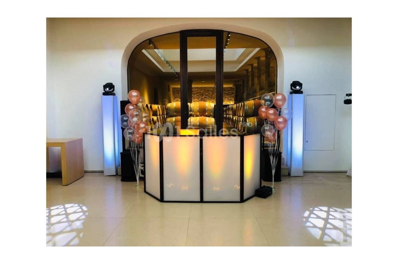 Comptoir lumineux décoré de ballons dans une salle moderne avec éclairage tamisé et sol en carrelage clair.
