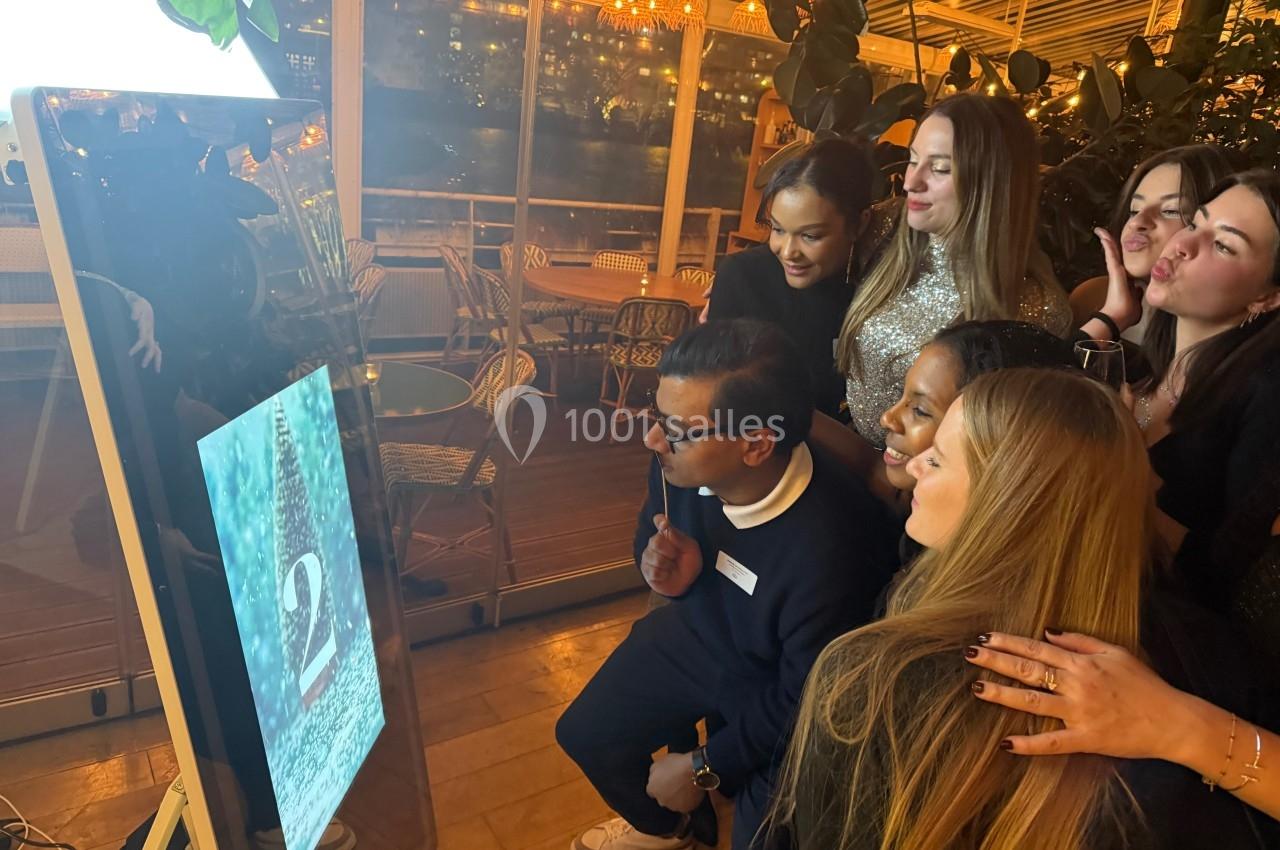 Des personnes rassemblées autour d'un miroir interactif dans un espace intérieur lumineux et décoré.