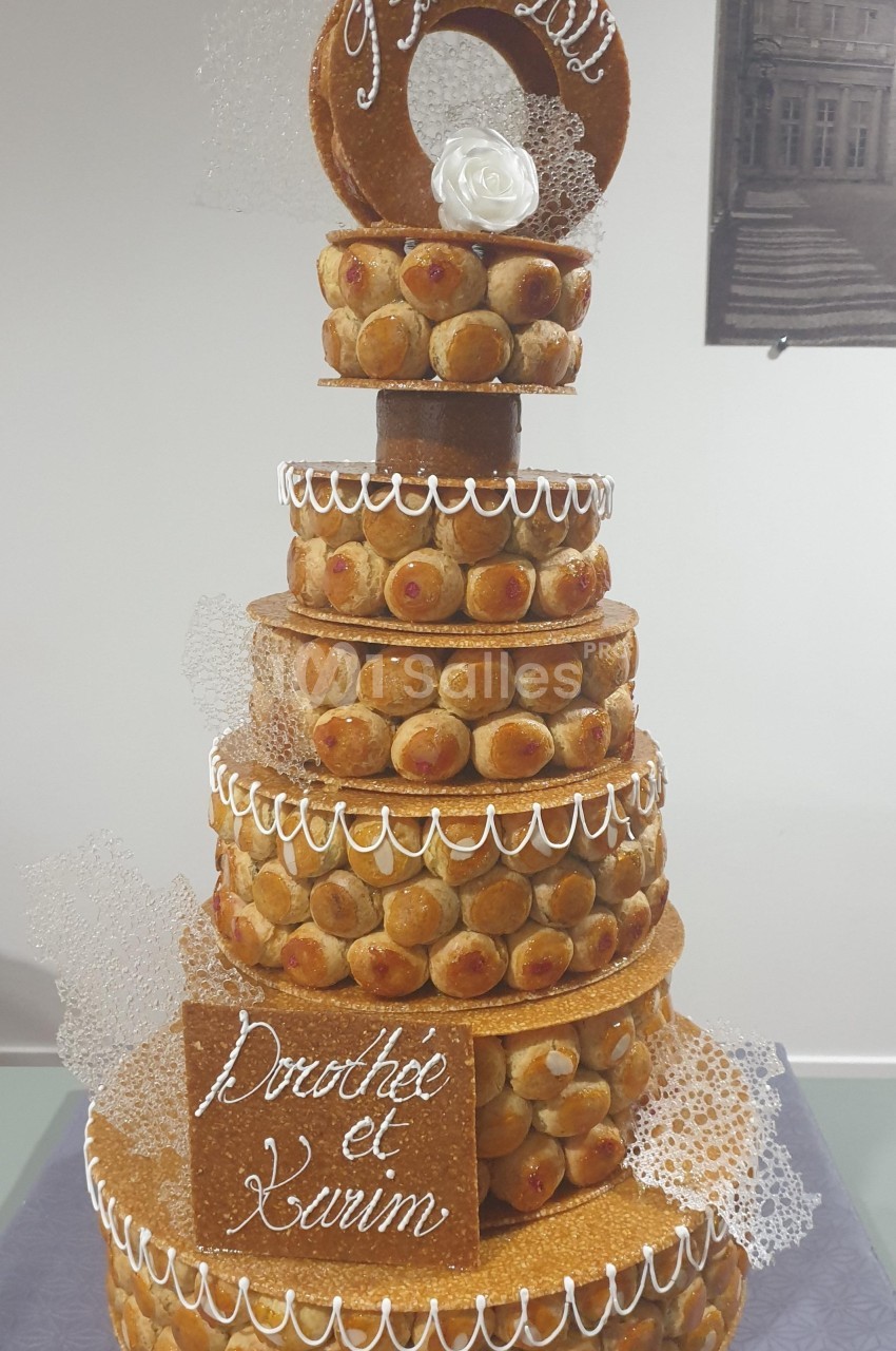 Pièce montée en choux et caramel décorée de dentelle de sucre, d'une rose blanche et d'une inscription personnalisée.