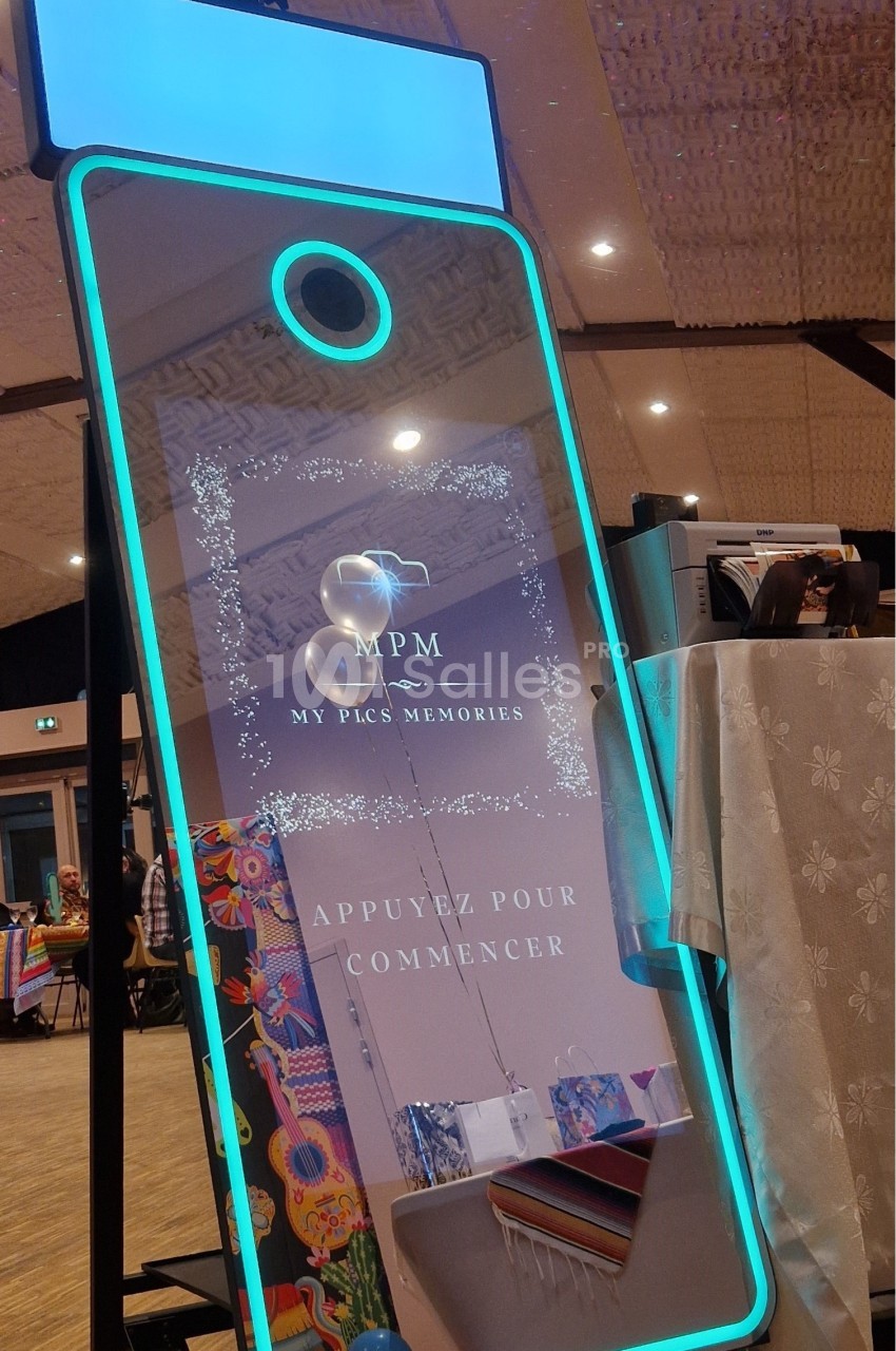 Miroir photobooth interactif avec éclairage LED, installé dans une salle événementielle.
