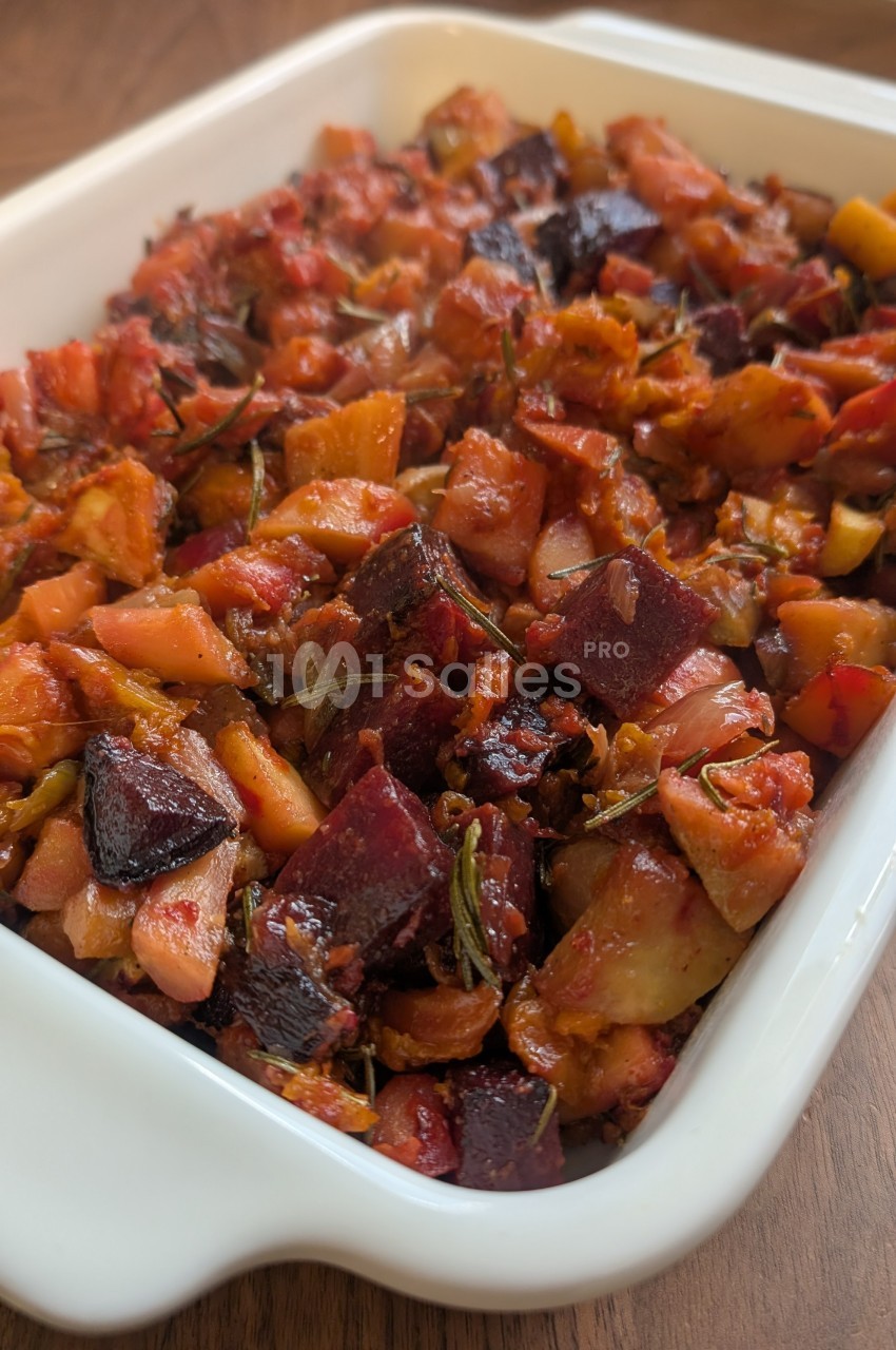 Plat de légumes rôtis comprenant betteraves, pommes de terre et herbes, présenté dans un plat blanc.