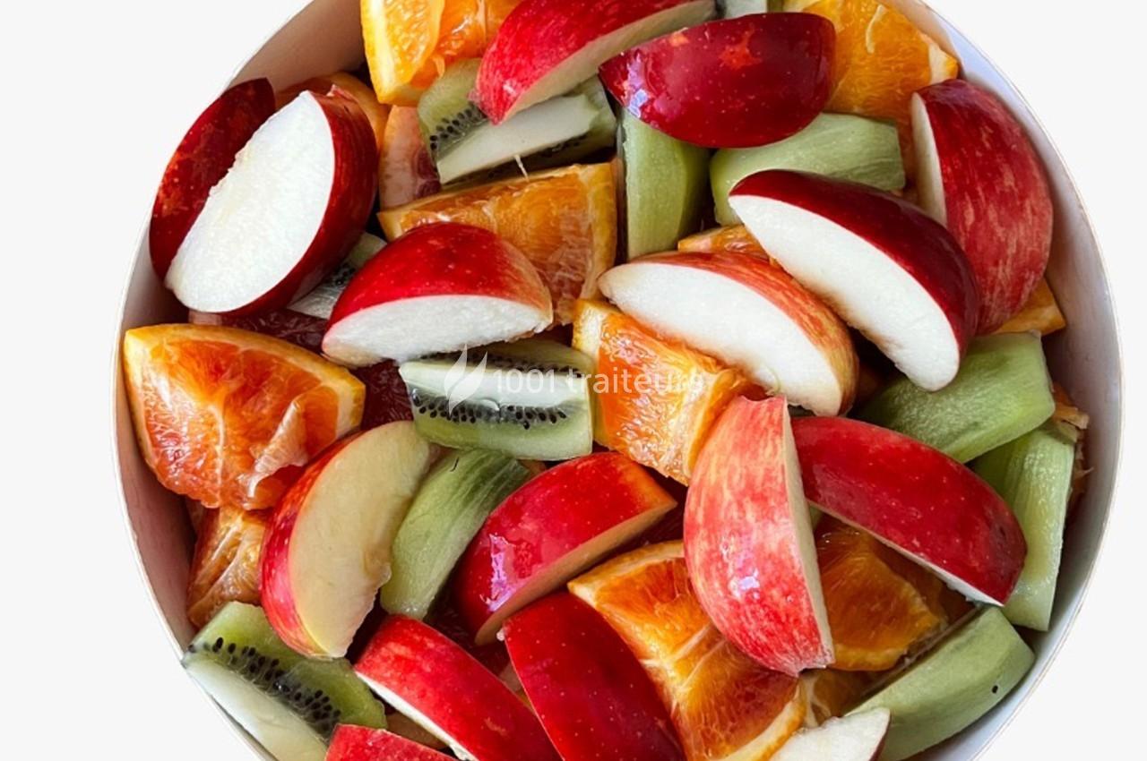 Assortiment de morceaux de pommes, oranges et kiwis frais dans un bol.