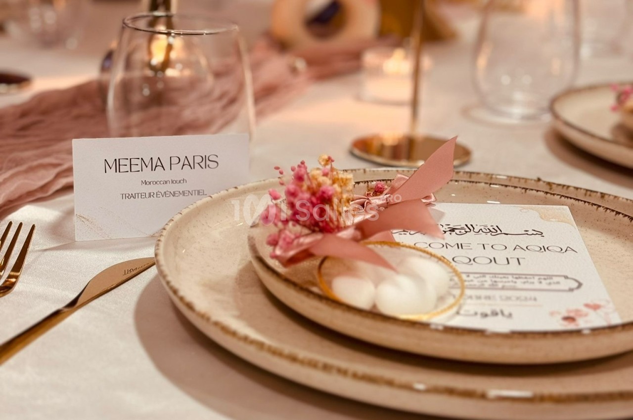 Carte de bienvenue et décoration florale posées sur une assiette en céramique, dans un cadre de table élégamment dressé.