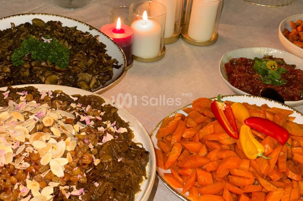 Assortiment de plats comprenant des carottes rôties, champignons sautés et garnitures, sur une table éclairée par des…