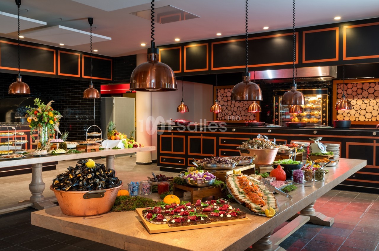 Buffet gastronomique avec fruits de mer, plats variés et décoration élégante dans une salle lumineuse.
