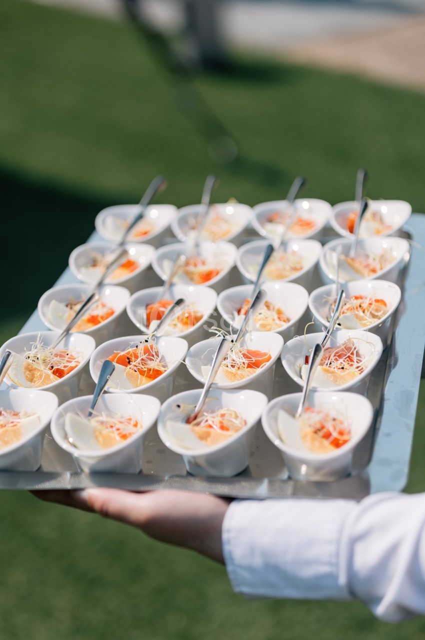Plateau de verrines individuelles contenant des entrées à base de légumes, servies avec des cuillères.