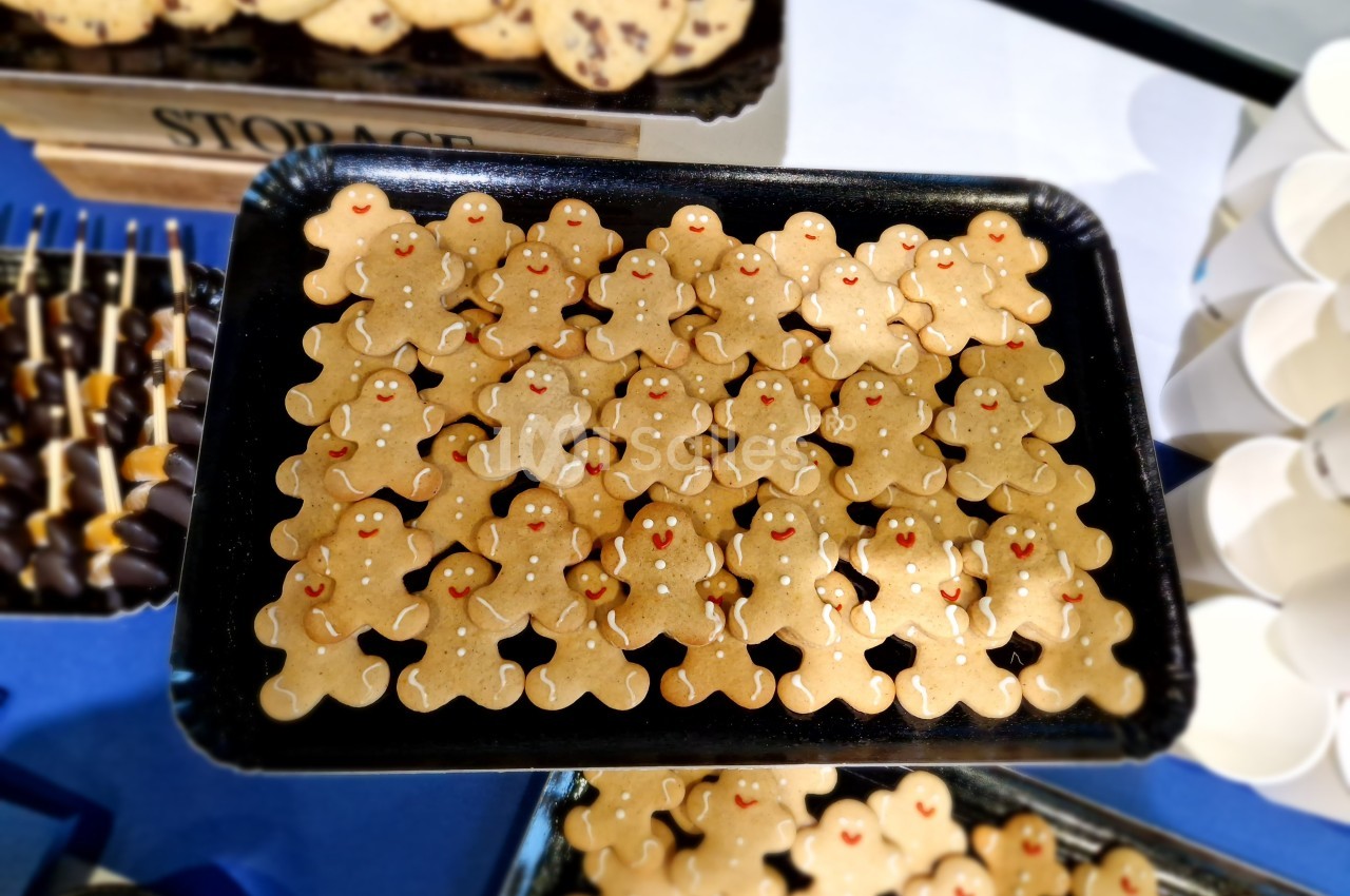 Plateau de biscuits en forme de bonshommes avec des décorations rouges, présenté sur une table.
