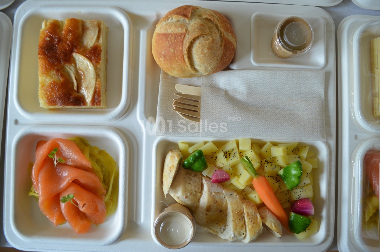 Plateau-repas avec saumon fumé, légumes, fromage, pain, dessert aux pommes et condiments.