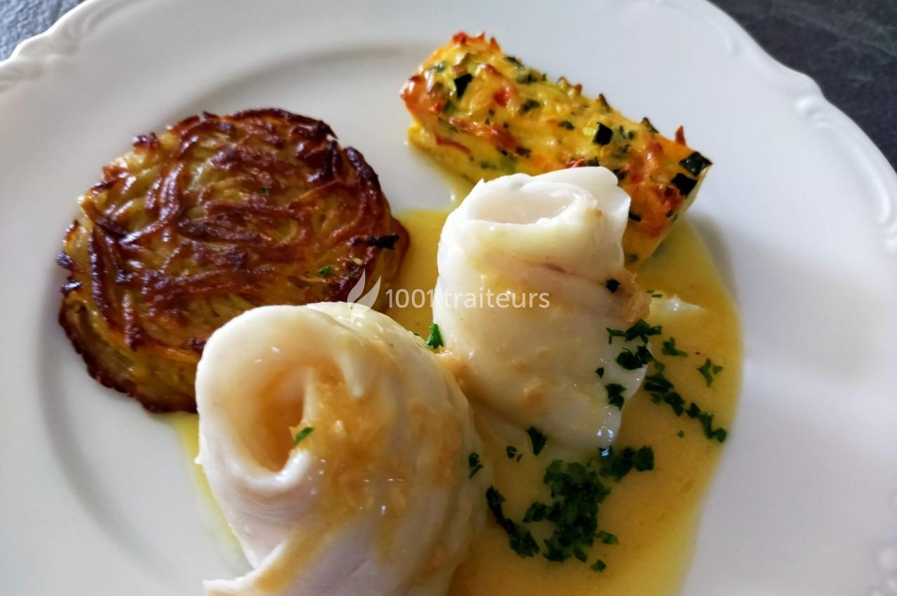 Assiette composée de filets de poisson en sauce, galette de pommes de terre et gratin de légumes.