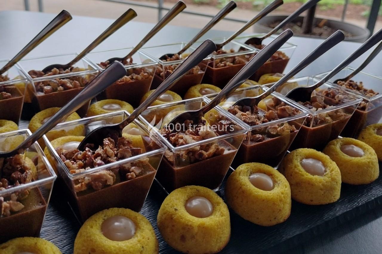 Desserts variés présentés sur un plateau, incluant des verrines au chocolat et des bouchées garnies de crème.