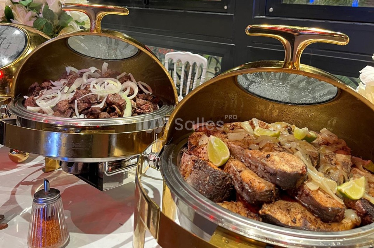 Plateaux de service en métal doré contenant des morceaux de viande grillée et de poisson garnis d'oignons et de quartiers de…