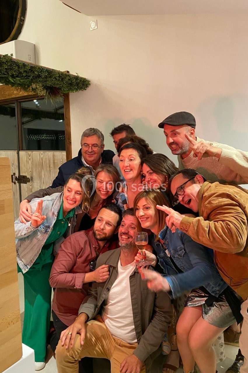 Un groupe de personnes souriantes posant ensemble dans un intérieur chaleureux.