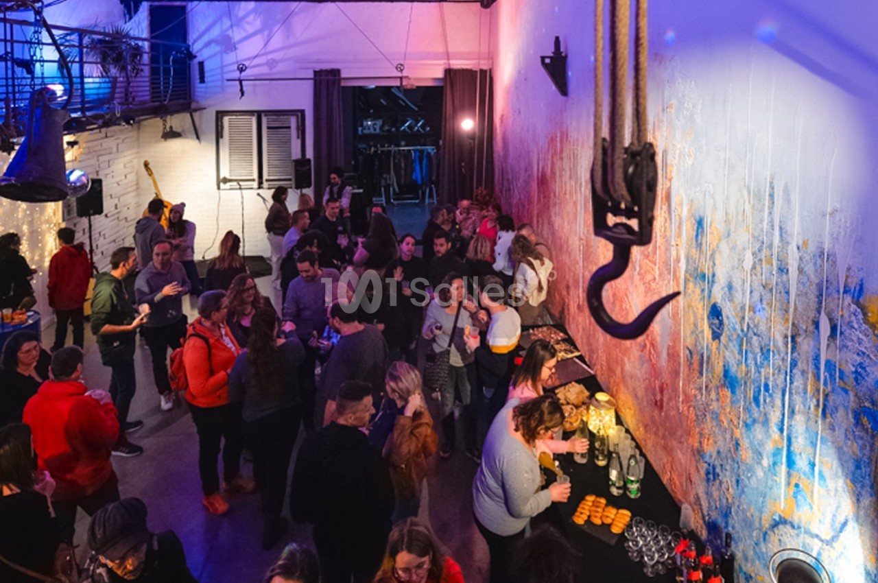 Groupe de personnes rassemblées dans un espace intérieur coloré avec un buffet et une ambiance conviviale.