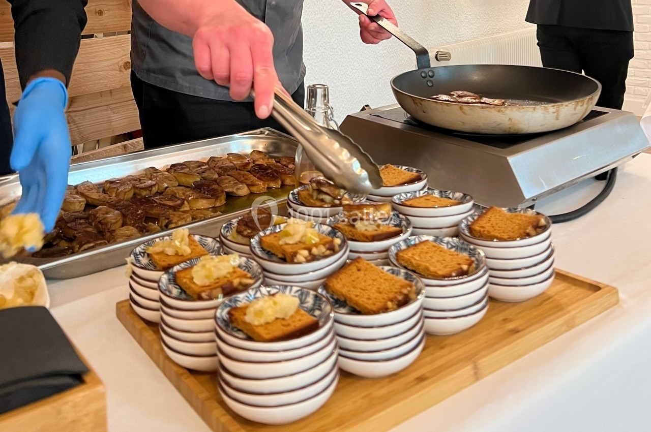 Des desserts individuels servis dans des bols, avec des biscuits et des garnitures, préparés par des cuisiniers en arrière…