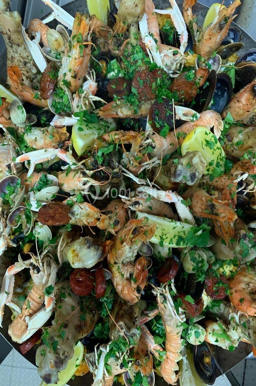 Plateau de fruits de mer variés avec crevettes, moules, langoustines, citron et persil haché.