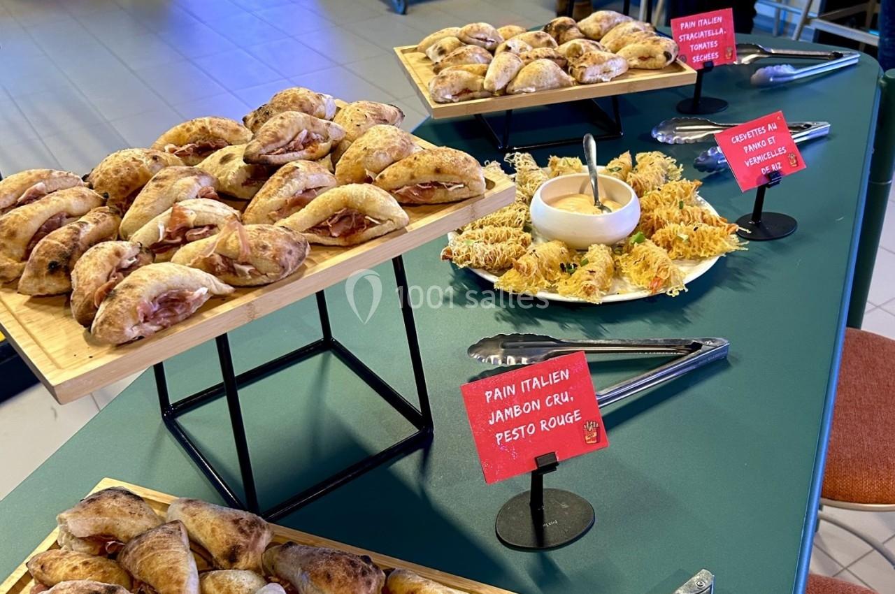 Plateau de mini-sandwichs et amuse-bouches variés présentés sur une table avec des étiquettes descriptives.