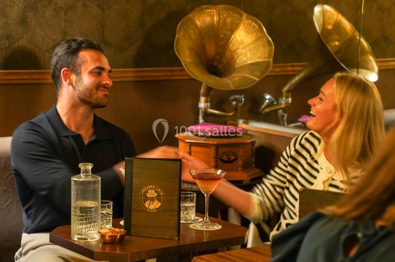 Un homme et une femme se serrent la main dans un café rétro avec des gramophones en arrière-plan.