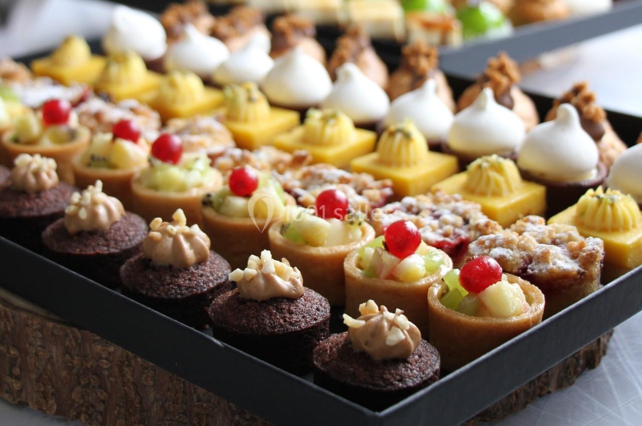 Plateau de mignardises variées comprenant tartelettes, mini-gâteaux et desserts décorés de fruits et crèmes.