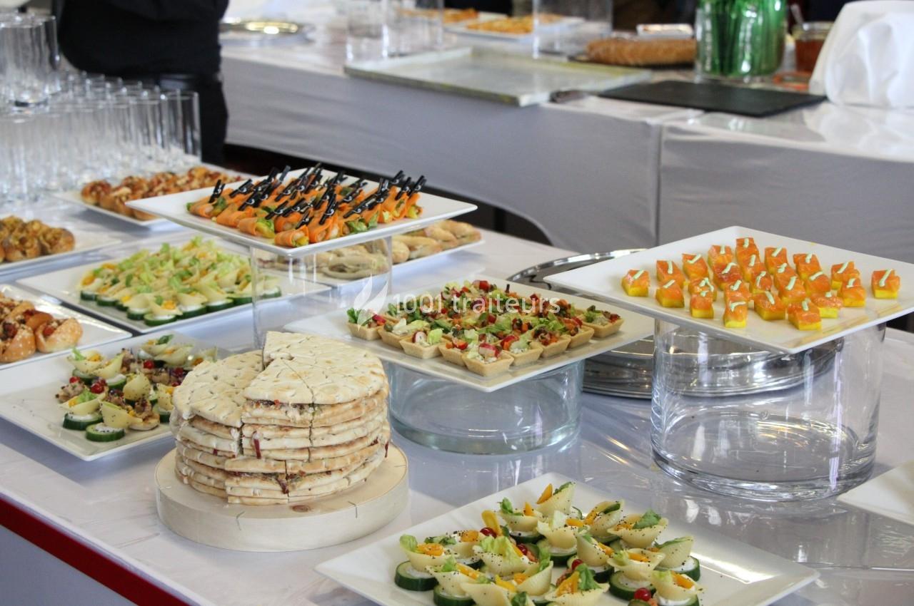 Buffet avec une variété de plats, incluant canapés, amuse-bouches et plateaux de présentation élégants.