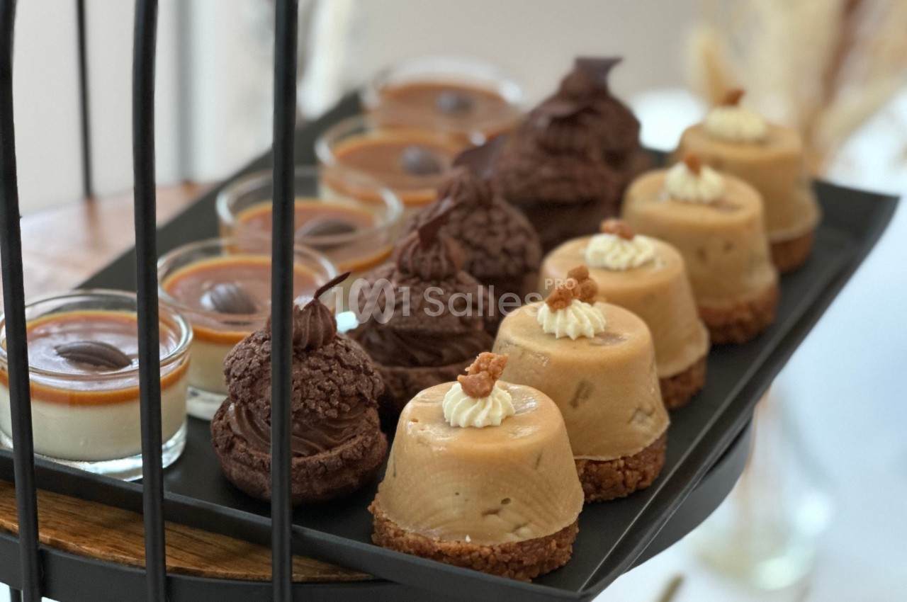 Plateau de desserts variés comprenant choux au chocolat, entremets au caramel et verrines de panna cotta.