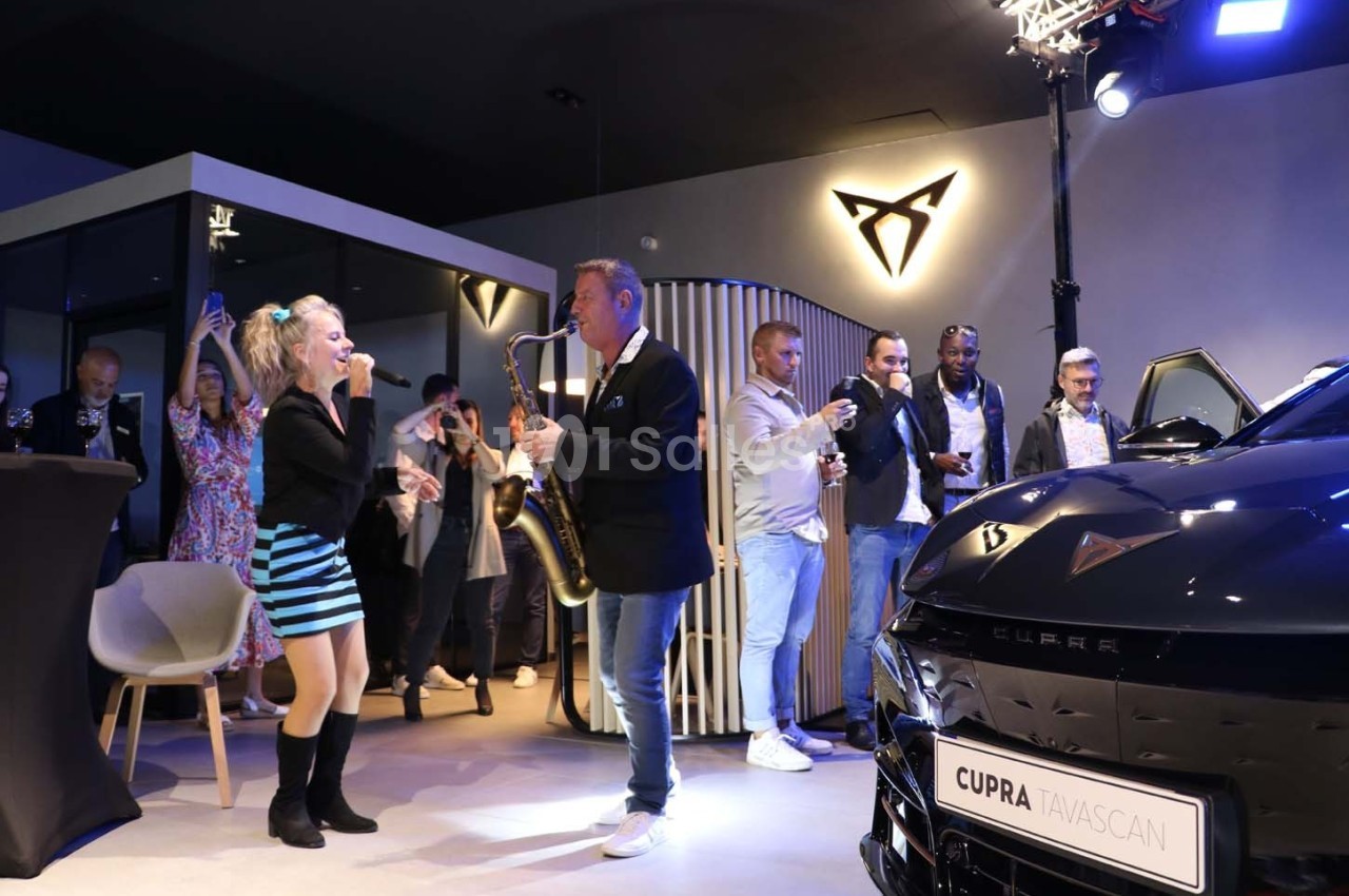Une chanteuse et un saxophoniste se produisent lors d'un événement dans un showroom automobile Cupra.