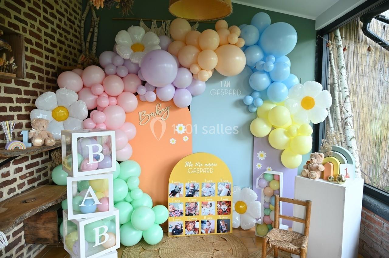 Décoration festive avec arche de ballons pastel, cubes ’BABY’, photos et éléments pour une fête d'enfant.