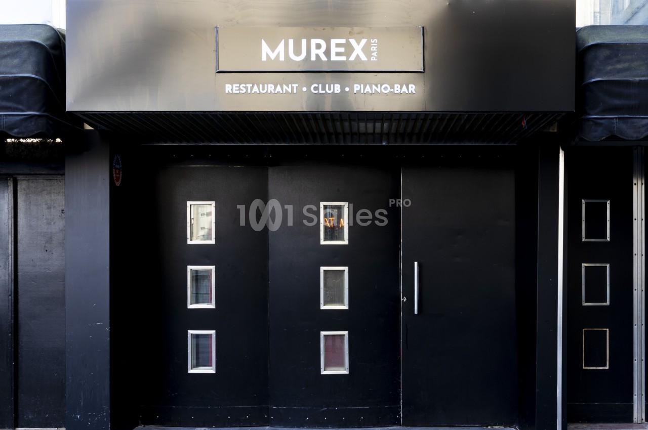 Façade noire d'un établissement nommé ’Murex Paris’ avec des portes vitrées et une enseigne indiquant restaurant, club…