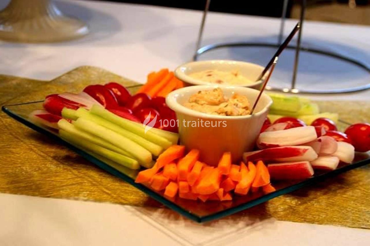 Assiette de crudités avec carottes, céleri, radis et tomates cerises, accompagnée de deux sauces en ramequins.