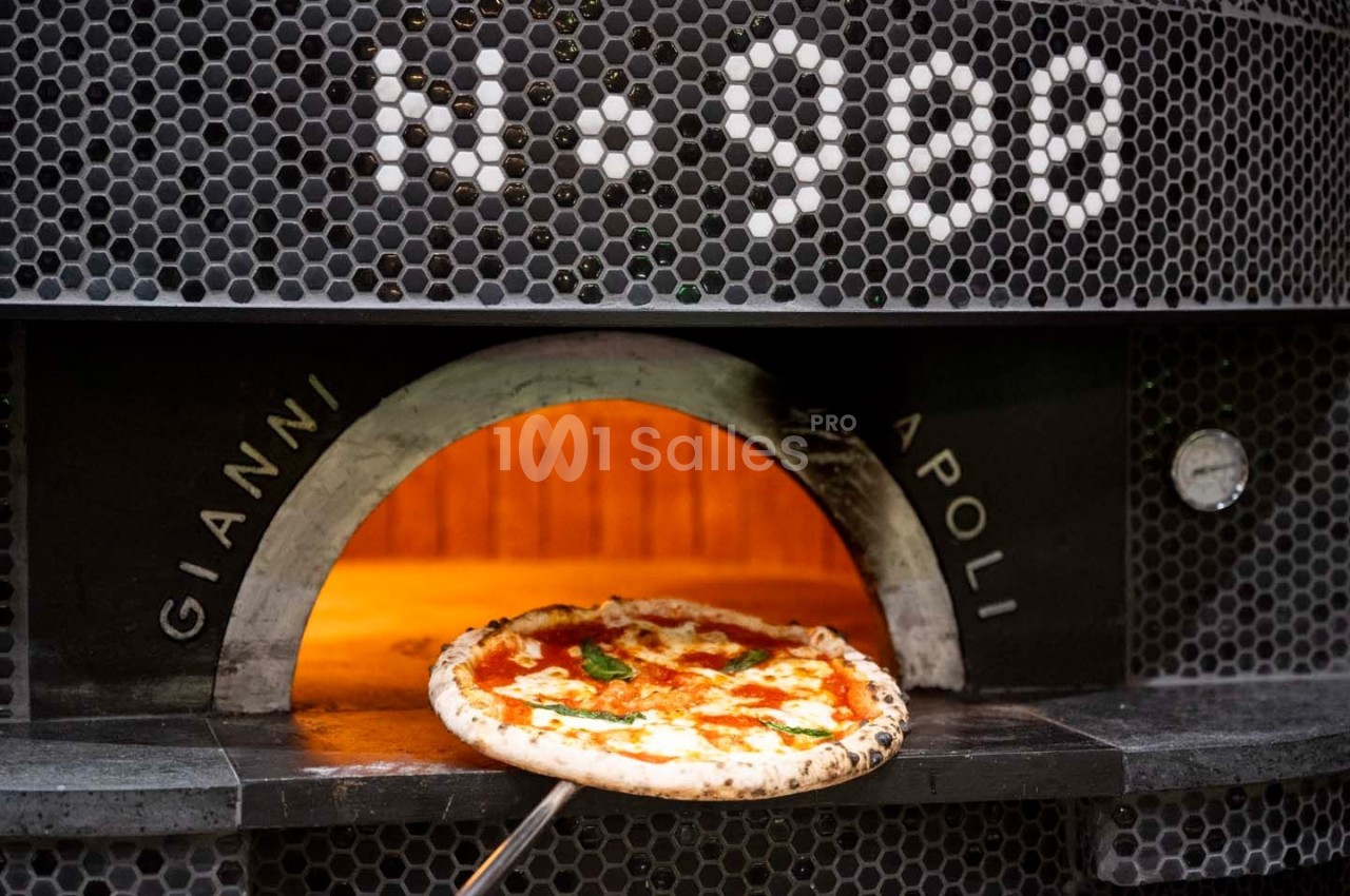 Pizza margherita sortant d'un four à bois noir avec l'inscription ’N° 900’ et ’Gianni Napoli’.